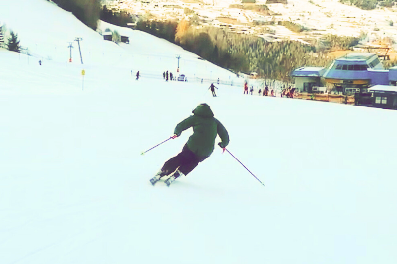 Skifahrerin von hinten auf einer Piste